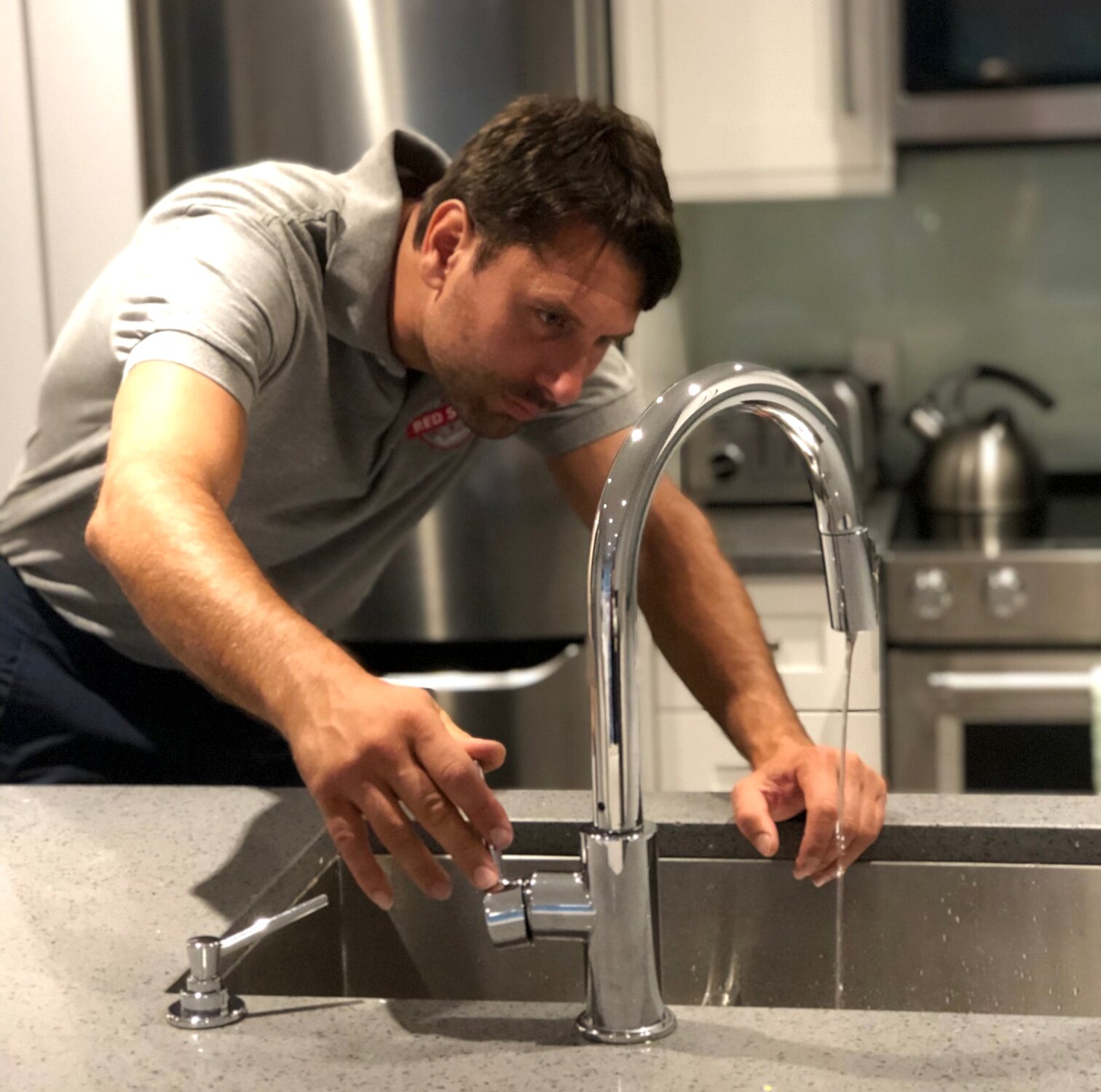 A Red Seal plumber checking a kitchen faucet